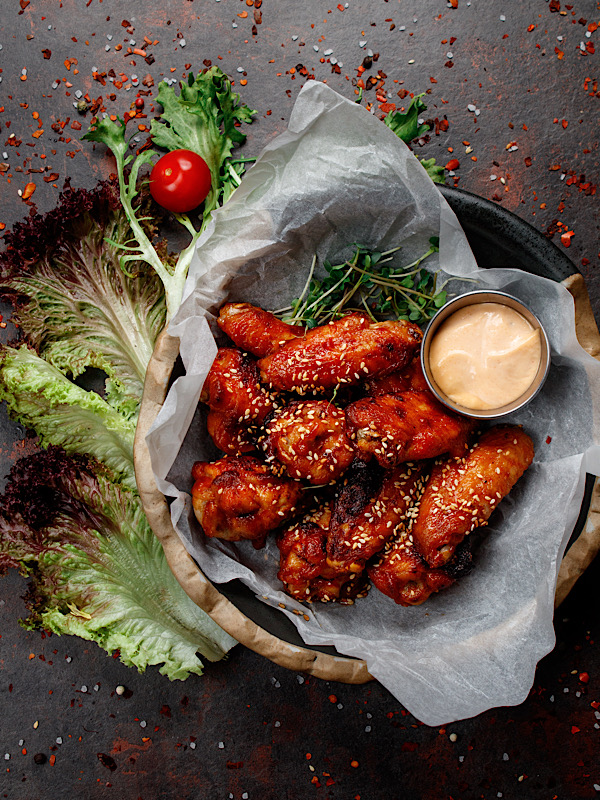 Glazed pork ribs with charred corn on a slate board
